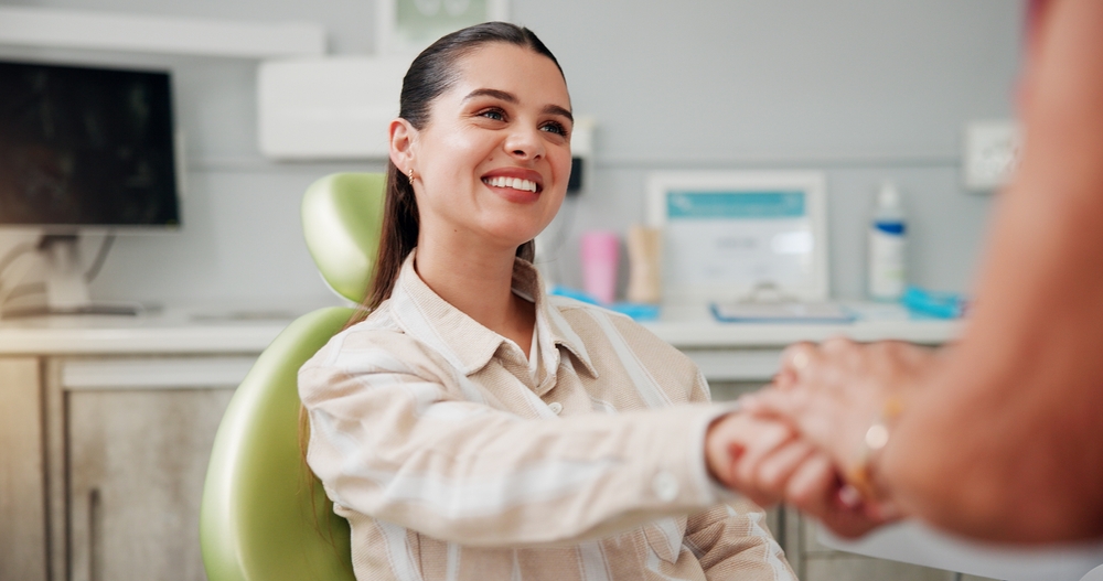 young woman shaking hands with a dental professional