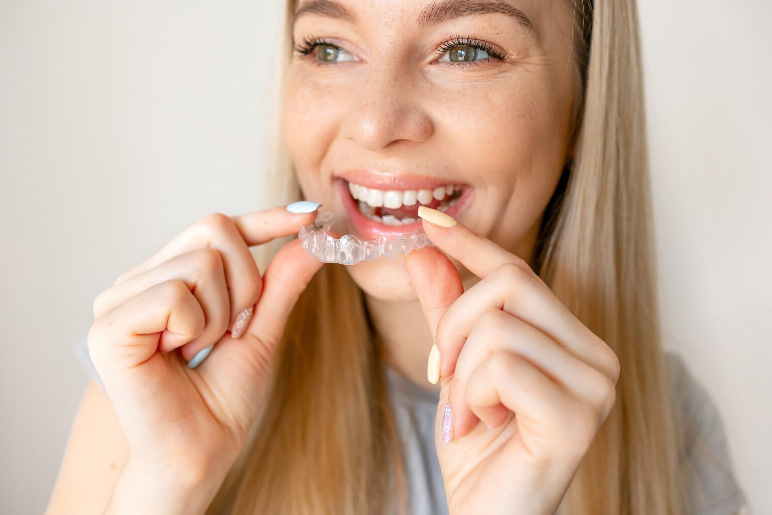 young woman placing her clear aligners in her mouth
