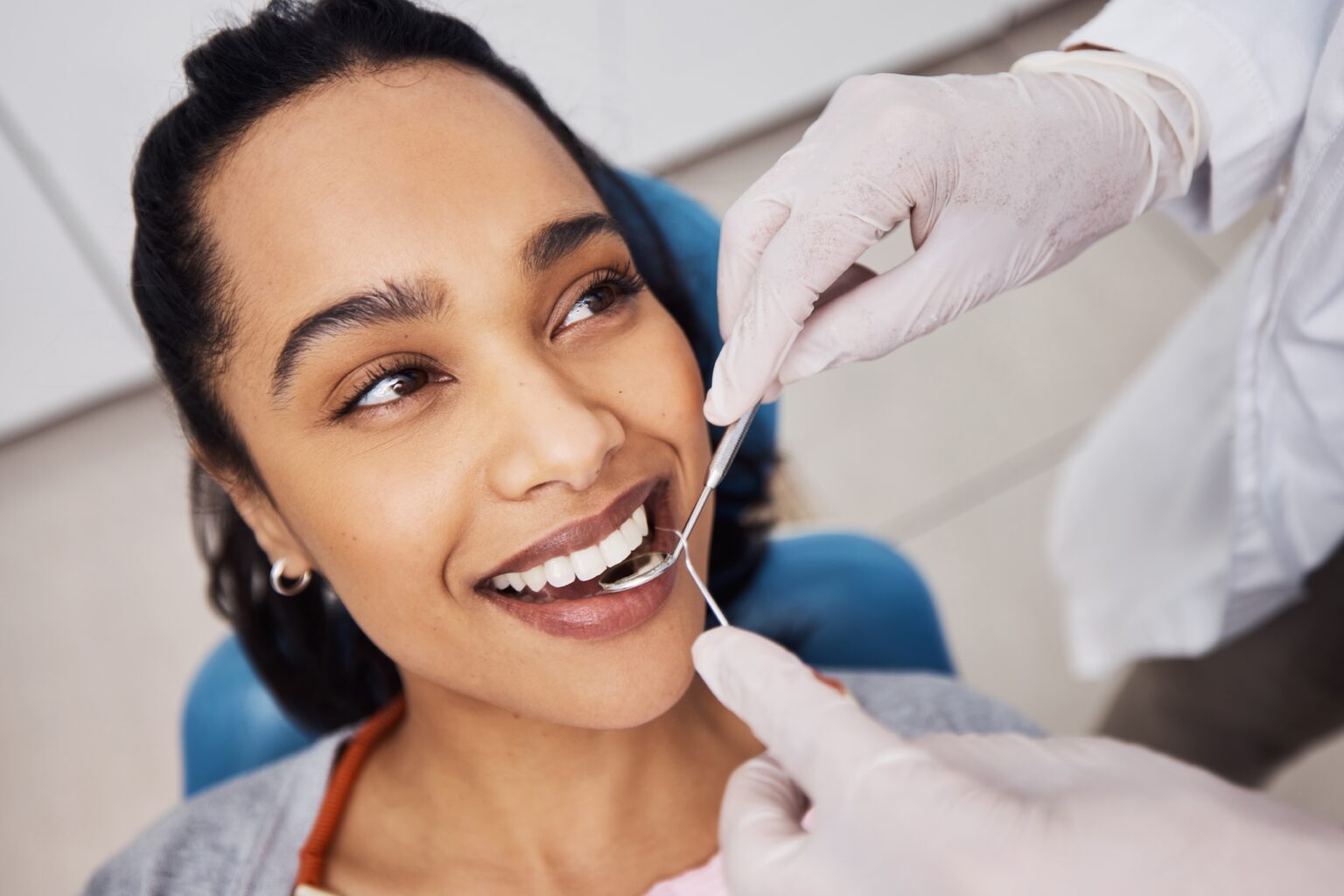 closeup of a dentist working on a female patients crown